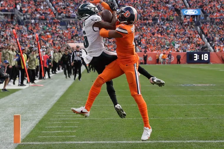 Eagles wide receiver DeVonta Smith catches a first quarter touchdown past Denver Broncos cornerback Pat Surtain II on Sunday, November 14, 2021 in Denver.