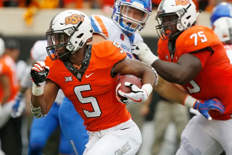 FILE - In this Sept. 15, 2018, file photo, Oklahoma State running back Justice Hill (5) runs past Boise State defensive end Durrant Miles, center, and teammate Marcus Keyes (75) and into the endzone with a touchdown in the first half of an NCAA college football game, in Stillwater, Okla. This season, four Big 12 backs are averaging at least 100 yards rushing per game in conference action. (AP Photo/Sue Ogrocki, File)