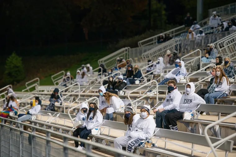 Students gather at Penn State's lacrosse field to watch the team play Ohio State on a big screen Saturday night on the University Park main campus. The university set up the socially distanced watch party.