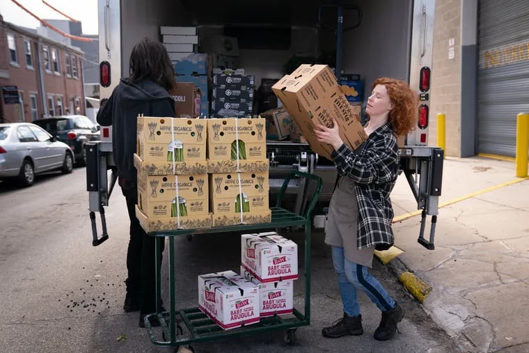 Patrick Hickey, merchandiser, (left) and Maureen Farley, produce team member, unload fruits and vegetables outside Riverwards Produce in Philadelphia on Friday.