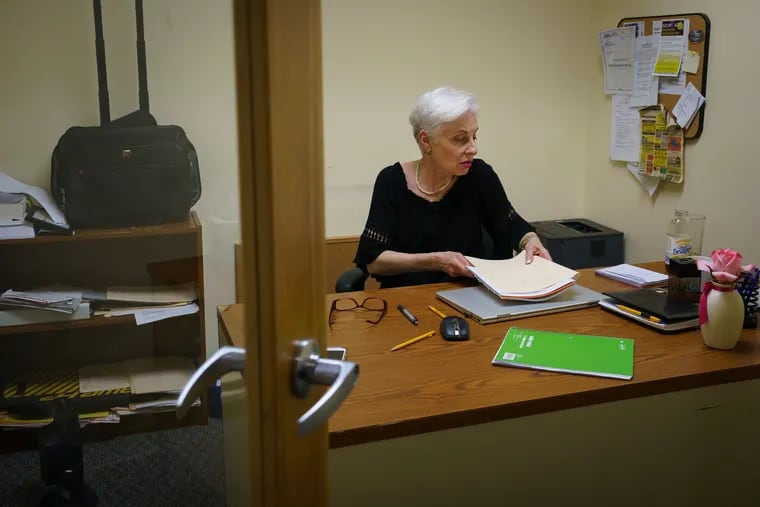 Naomi Brownstein, at her desk in her West Mount Airy office, offers secretarial services to consumers in simple legal matters such as uncontested divorce. The state Attorney General's Office appears to have a problem with that.