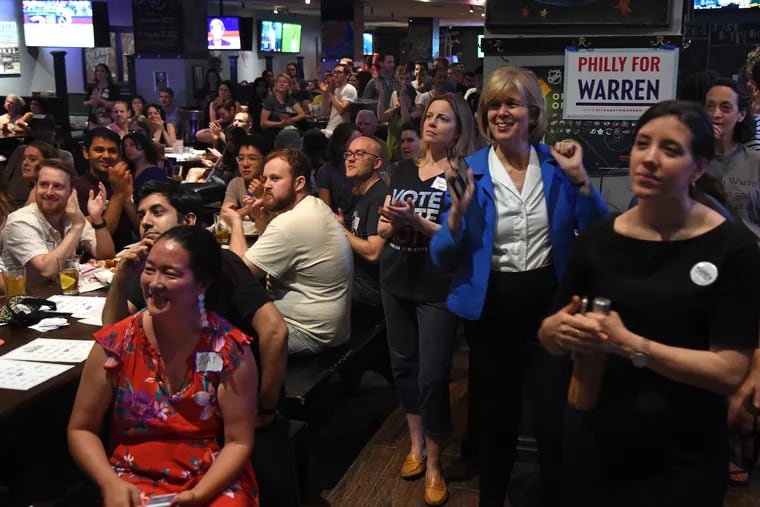 Supporters of Sen. Elizabeth Warren watch the big-screen TV as Philly for Warren hosts a watch party during the first Democratic presidential primary debate June 26, 2019, at Field House in Center City. Second from right in blue jacket is Elizabeth Vale, a former colleague of Warren's.
