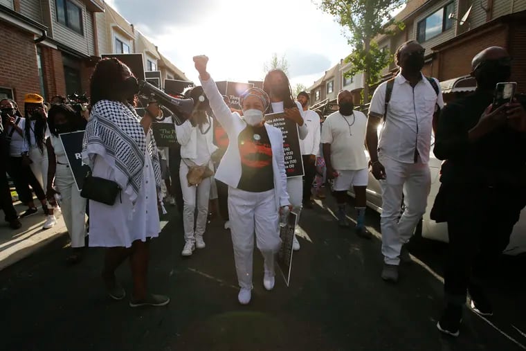 MOVE member Pam Africa leads a group along the 6200 block of Osage Avenue in West Philadelphia on Thursday, the 36th anniversary of the MOVE bombing and the city of Philadelphia's first official day of remembrance for MOVE.