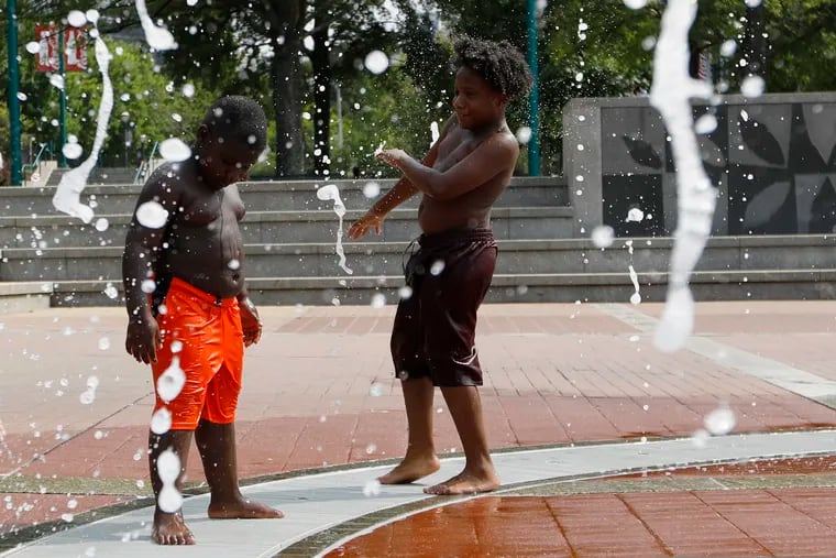 Kai Frazier and Chance Seawright, brothers visiting from Aiken, South Carolina, cool off while playing in the Fountain of Rings in Centennial Olympic Park, Monday, Aug. 12, 2019, in Atlanta.