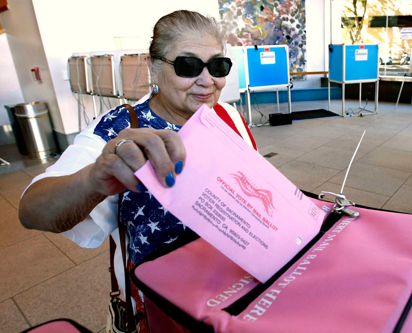 In this Nov. 5, 2018, file photo, Yolanda Jimenez casts her mail-in ballot in at the voting center at the California Museum in Sacramento, Calif. 