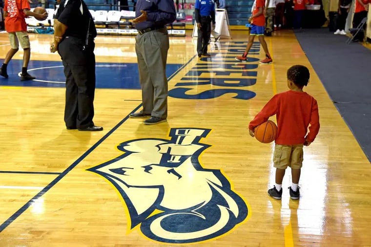 Three year-old Saire Rembert watches the warmups during this week’s 12th annual Danny Rumph Classic Basketball Tournament, at La Salle’s Tom Gola Arena.