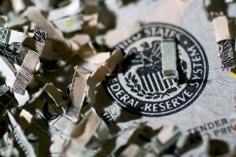 Shredded currency surrounds the seal of the U.S. Federal Reserve in Washington. (Andrew Harrer / Bloomberg News)