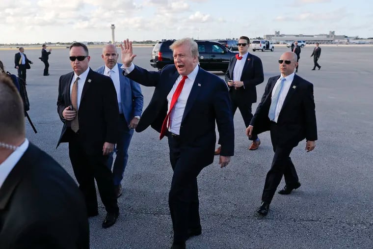 In this April 18, 2019, file photo, President Donald Trump, center, surrounded by members of the Secret Service, walks across the tarmac to begin to greet supporters during his arrival at Palm Beach International Airport, in West Palm Beach, Fla.