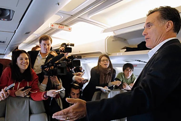 Mitt Romney talking to reporters on his campaign plane in Bedford, Mass., on Wednesday. He was traveling to South Carolina the day after easily winning the New Hampshire primary. (Charles Dharapak / Associated Press)