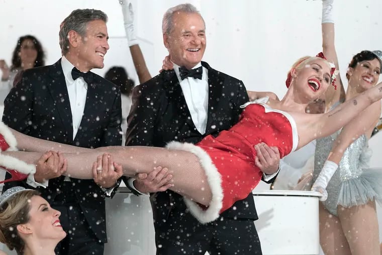 Bill Murray and George Clooney, left, hold Miley Cyrus in the  holiday special “A Very Murray Christmas.”