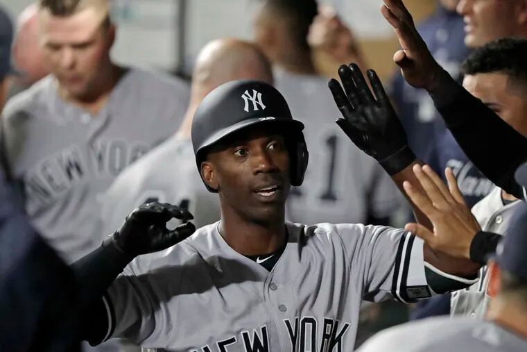 FILE - In this Sept. 7, 2018, file photo, New York Yankees' Andrew McCutchen is greeted in the dugout after he hit a two-run home run during the third inning of a baseball game against the Seattle Mariners, in Seattle. A person familiar with the negotiations tells The Associated Press that All-Star outfielder Andrew McCutchen and the Philadelphia Phillies have agreed to a $50 million three-year contract. The person spoke on condition of anonymity Tuesday, Dec. 11, 2018, because the agreement, which includes a club option for 2022, is subject to a successful physical.(AP Photo/Ted S. Warren, File)