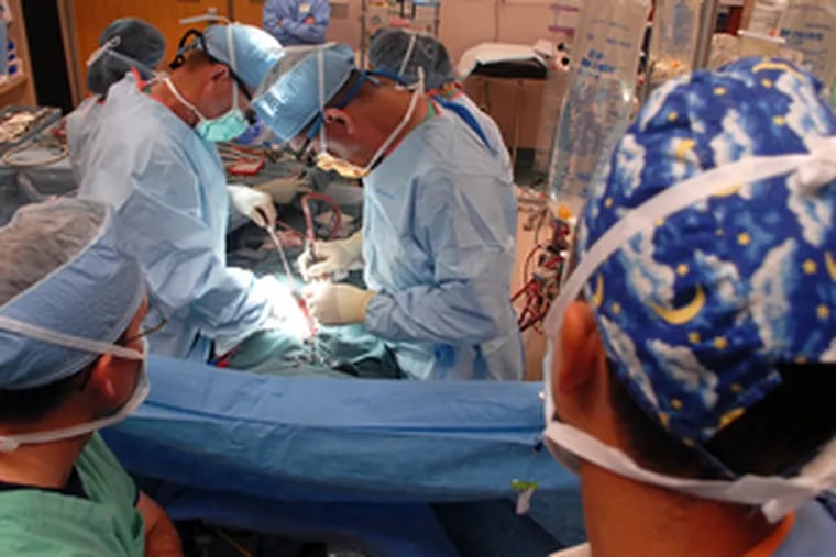 Doylestown Hospital surgeon Joseph S. Auteri (right) says he was laid off for refusing the COVID-19 vaccine. He is raising money through GoFundMe to sue the hospital. In this 2007 photo, he performs an open-heart valve operation.