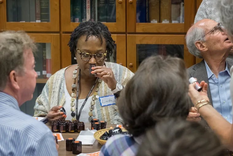 On Tuesday, August 9, a few dozen people with Functional Anosmics assembled for a Smell Training Workshop at Monell Chemical Senses Center in West Philadelphia with the goal of learning how to smell again. Here, Linda Wright Moore, center, attempts to identify a scent.