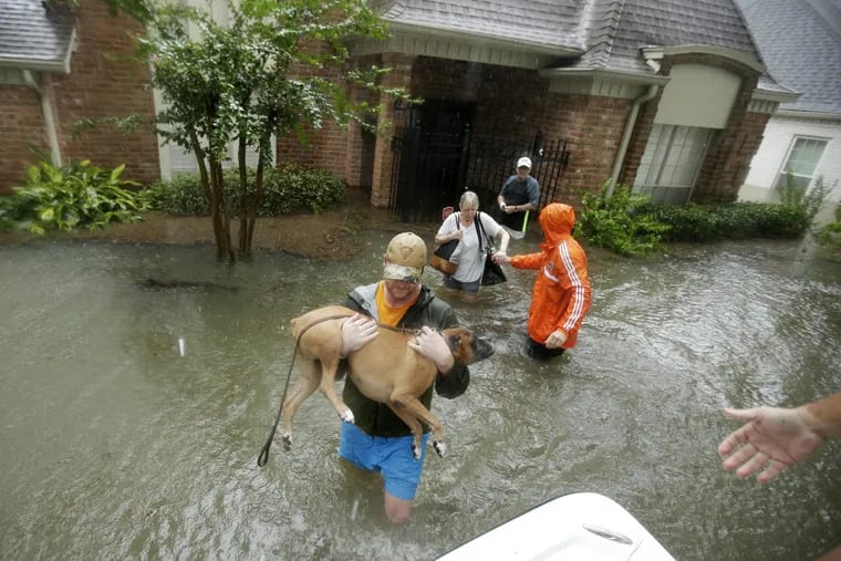 Volunteers evacuate a neighborhood in west Houston inundated by floodwaters.