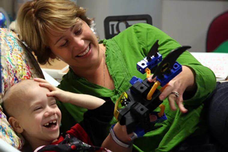 Everest Grenke Leach, 5, plays with his mother, Liz Grenke Leach, at Children’s Hospital. He is undergoing immunotherapy as treatment for neuroblastoma. (Laurence Kesterson / Staff Photographer)