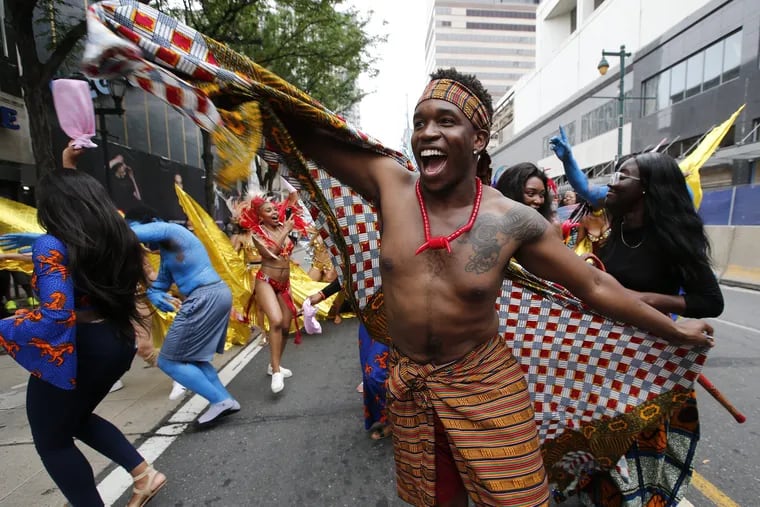 Chi Oriji of the Atlantic City Carnival leads the group in the winin dance during the Juneteenth Parade, recognizing the end of slavery in America, along East Market Street on Saturday, June 23, 2018. YONG KIM / Staff Photographer