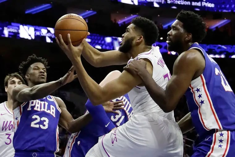 Minnesota Timberwolves' Karl-Anthony Towns, center, tries to get a shot past Philadelphia 76ers' Joel Embiid, right, and Jimmy Butler during the first half of an NBA basketball game, Tuesday, Jan. 15, 2019, in Philadelphia. (AP Photo/Matt Slocum)