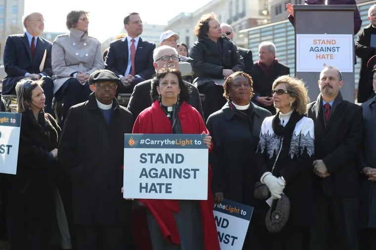 Rev. Ruth Santana-Grace (in red) stands with other religious leaders as the Jewish Federation holds a “Stand Against Hate” rally in March at Independence Hall to protest vandalism of Jewish cemeteries and hate crimes.