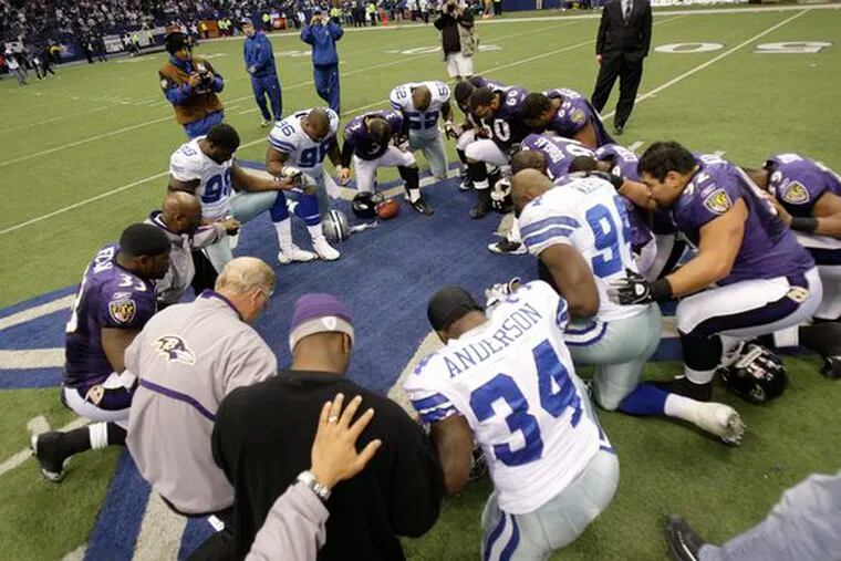 Cowboys players and coaches gather at midfield for a prayer after the final game at Texas Stadium. Dallas bid farewell by losing to Baltimore with a late meltdown.