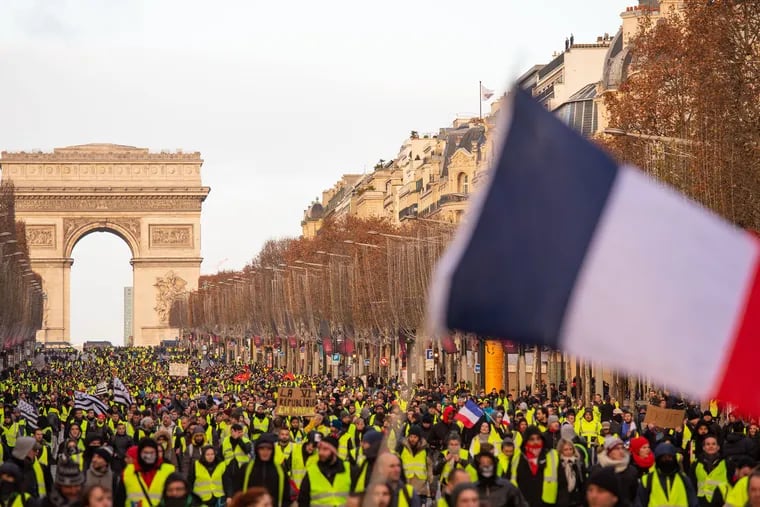 A massive crowd walks along the Champs Elysees during anti-government demonstrations on Dec. 8, 2018 in Paris. President Emmanuel Macron promised a monthly rise in France's minimum wage among measures aimed at placating the Yellow Vest protest movement.  (Omer Messinger/Zuma Press/TNS)