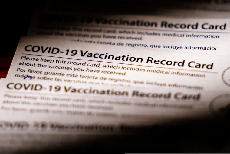 Shown are COVID-19 vaccination record cards in Glenside, Pa., Monday, Dec. 13, 2021. Philadelphia officials announced Monday that proof of vaccination will be required starting Jan. 3 for bars, restaurants, indoor sporting events, movie theaters and other places where people eat indoors close to each other. (AP Photo/Matt Rourke)