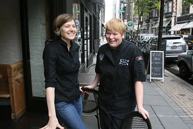 Valerie Safran (left) and Marcie Turney at Mediterranean-style Barbuzzo, their third restaurant on the block. Behind them is Verde, their flower and chocolate shop. (Charles Fox / Staff Photographer)