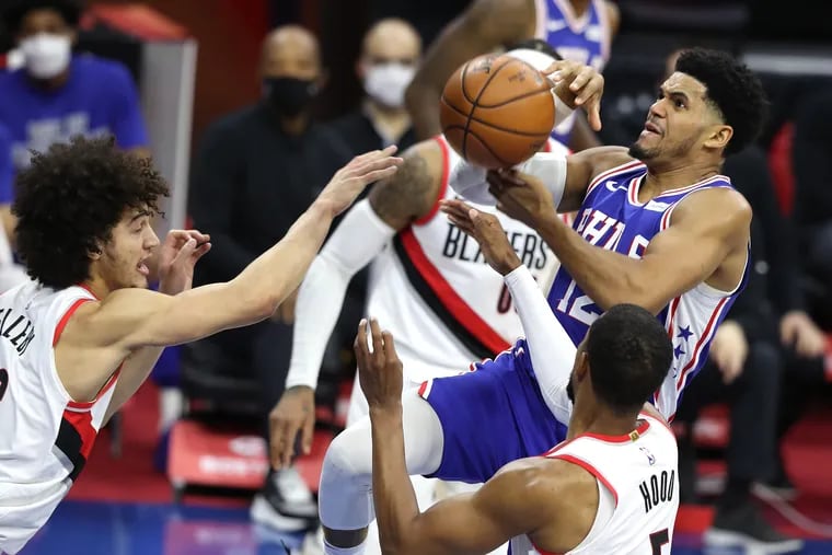 Tobias Harris (right) of the SIxers loses the ball as he goes up for a shot against the Trail Blazers during the first half.
