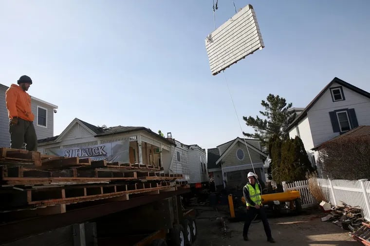 Steve Hauck, right, owner of SJ Hauck House Movers, guides a wall section from a house in Avalon, N.J., onto a flatbed truck for transport on Friday, Feb. 9, 2018. The Victorian-style house was slated to be torn down for redevelopment, but is instead being taken apart to be moved to Egg Harbor Township. TIM TAI / Staff Photographer