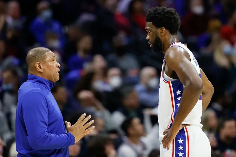 Sixers coach Doc Rivers talks to center Joel Embiid during a game against the Cleveland Cavaliers at the Wells Fargo Center.