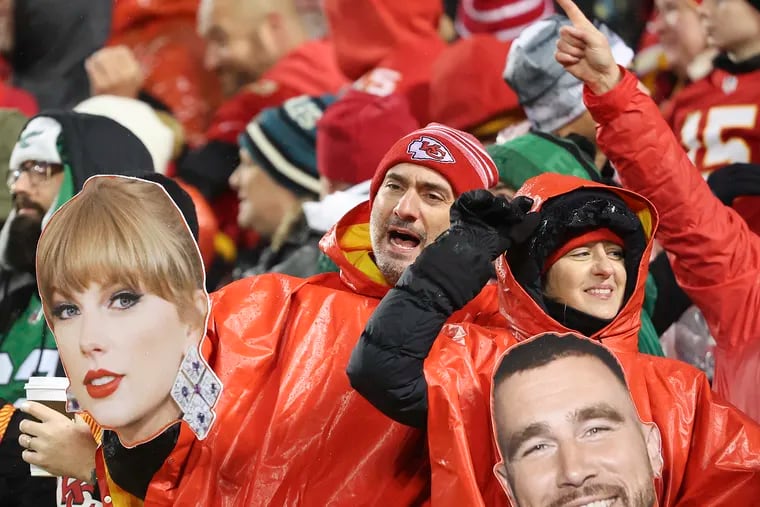 Kansas City Chiefs fans hold photographs of Chiefs tight end Travis Kelce (right) and entertainer Taylor Swift at GEHA Field at Arrowhead Stadium in Kansas City, Mo., on Monday, Nov. 20, 2023.