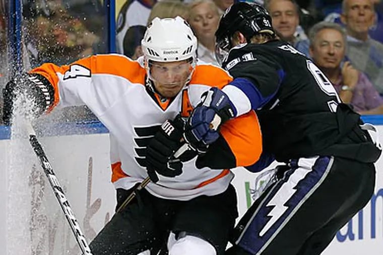 Kimmo Timonen is bumped off the puck by the Lightning's Steven Stamkos. (Chris O'Meara/AP)