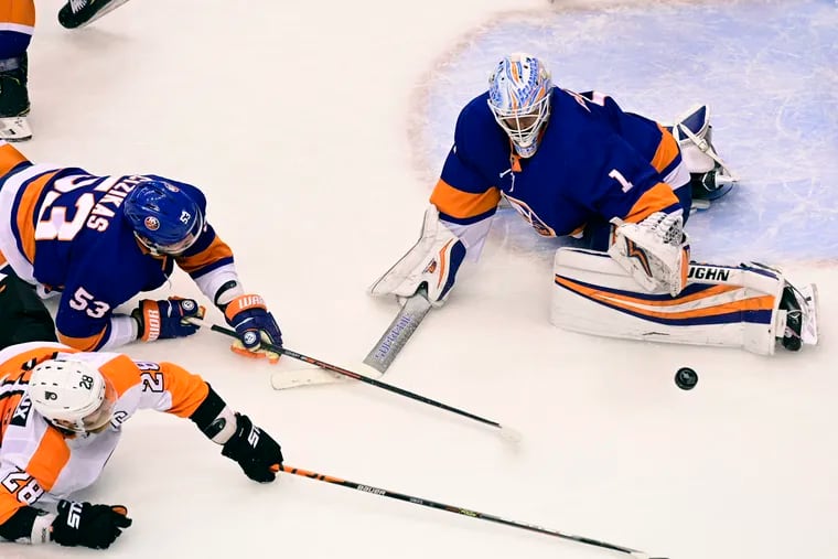 Islanders goaltender Thomas Greiss (right) makes a save on Flyers forward Claude Giroux as Casey Cizikas (53) defends during the third period of the Islanders' 3-2 victory Sunday night.