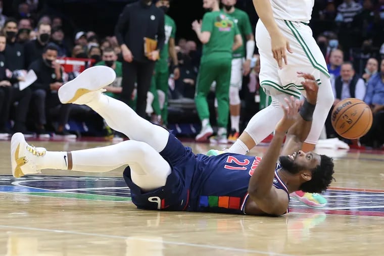 Joel Embiid of the Sixers takes a fall during their game at the Wells Fargo Center against the Celtics on Feb. 15, 2022.