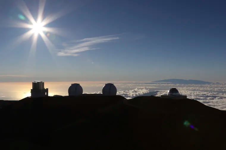The sun sets behind telescopes at the summit of Mauna Kea, Hawaii's tallest mountain, Sunday, July 14, 2019. Hundreds of demonstrators gathered at the base of Hawaii's tallest mountain to protest the construction of a giant telescope on land that some Native Hawaiians consider sacred. State and local officials will try to close the road to the summit of Mauna Kea Monday morning to allow trucks carrying construction equipment to make their way to the top. Officials say anyone breaking the law will be prosecuted. Protestors have blocked the roadway during previous attempts to begin construction and have been arrested. (AP Photo/Caleb Jones)