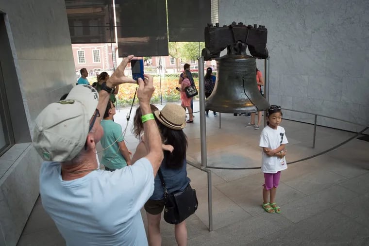 Tourists taking pictures of and posing with the Liberty Bell this month.