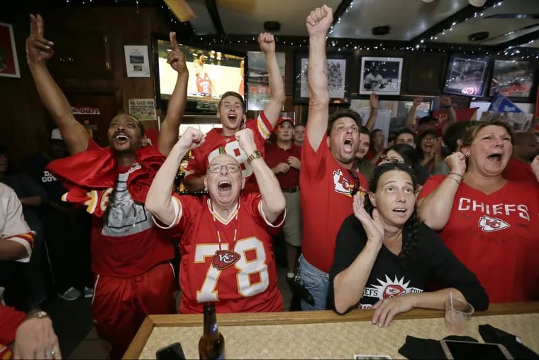From left: Moe Warwick of West Philadelphia, Steve Barker of Sacremento, Calif., Chris Stanton of Jenkintown, Michele Chermela — an Eagles fan — of Willow Grove, and Lindsi Dull of Akron, Pa. cheer for their teams in the closing moments of the Eagles-Chiefs  football game at Big Charlie’s Saloon in South Philadelphia.