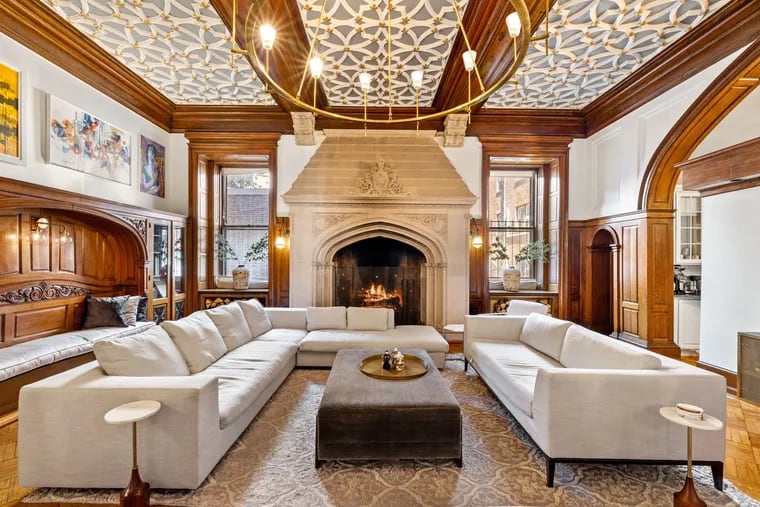 A massive, wood-burning fireplace is the focal point of the living room, where a 72-inch-wide chandelier modernizes the original, ornate plaster ceiling.