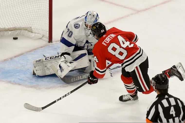 Chicago Blackhawks left wing Alexandre Fortin (84) scores a goal past Tampa Bay Lightning goaltender Louis Domingue (70) during the first period of an NHL hockey game on Sunday Oct. 21, 2018, in Chicago. (AP Photo/Matt Marton)