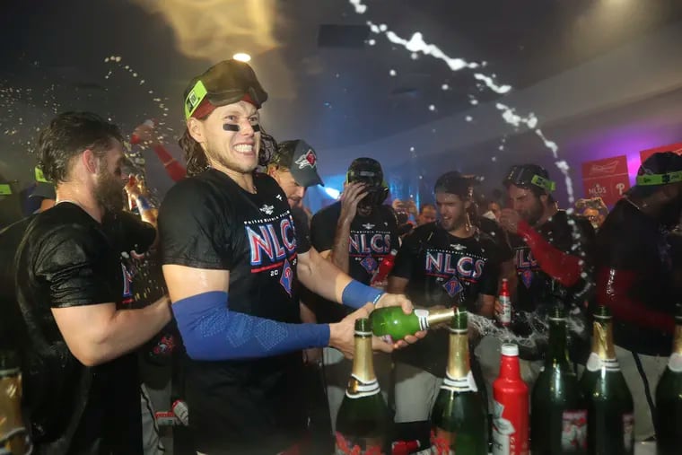 Phillies third baseman Alec Bohm sprays champagne celebrating after the Phillies beat the Braves.