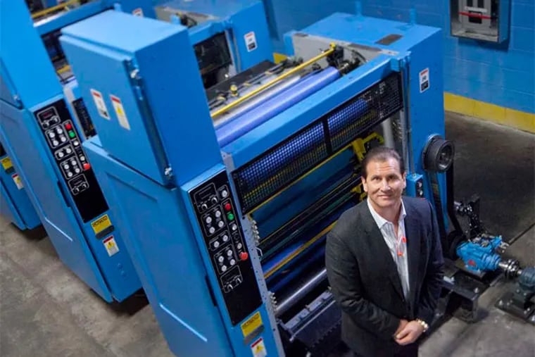 Nicholas Maiale, president and CEO of Inserts East Inc. in Pennsauken, with his company's eight-unit press. He's thinking of adding another production line. (David M Warren / Staff Photographer)