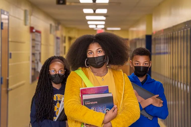 From left, Imani Love, 7th grader; Caleyse Utley, 7th grader; and Keiden Warren, 5th grader pose for a photo  wearing their face masks on the hallway at Lawnside Elementary School in Lawnside, N.J., Monday, February 7, 2022. Gov Murphy plans to lift a mask mandate for schools, effective March, when teachers and students will no longer be required to wear them.