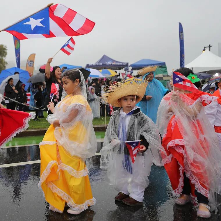 Milagros Rivera (left) dances with Alexann Garcia (center) during the Puerto Rican Day Parade in Philadelphia in 2023.