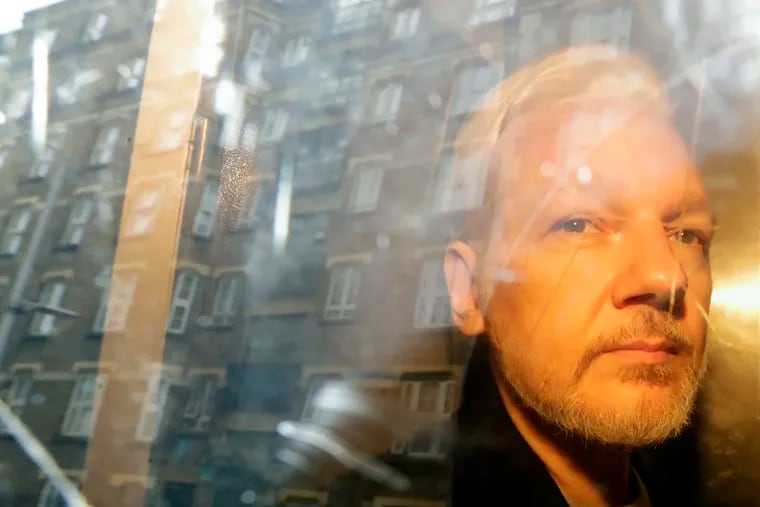 Buildings are reflected in the window as WikiLeaks founder Julian Assange is taken from court in 2019.