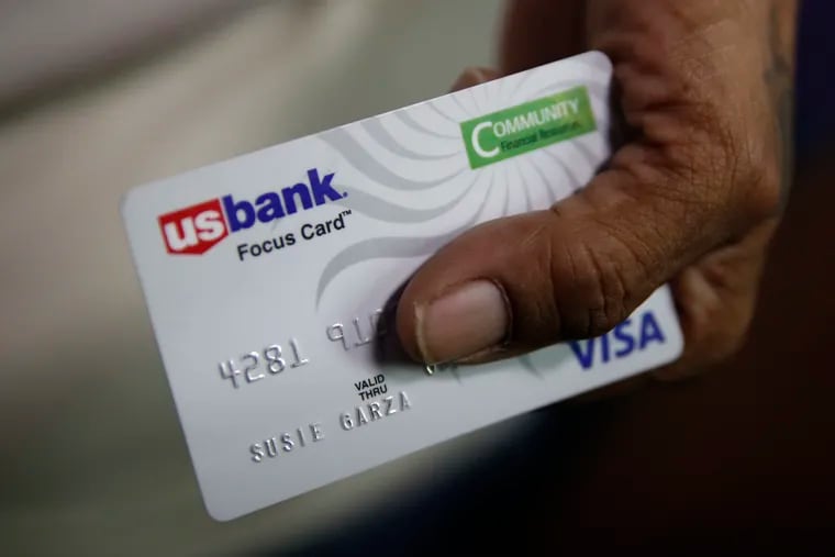 In this Aug. 14, 2019, file photo, Susie Garza displays the city-provided debit card she receives monthly through a trial program in Stockton, Calif. A study of people in California who received $500 a month for free says they used it to pay off debt and get full-time jobs. A pair of independent researchers reviewed data from the first year of the study and released their findings on Wednesday, March 3, 2021.
