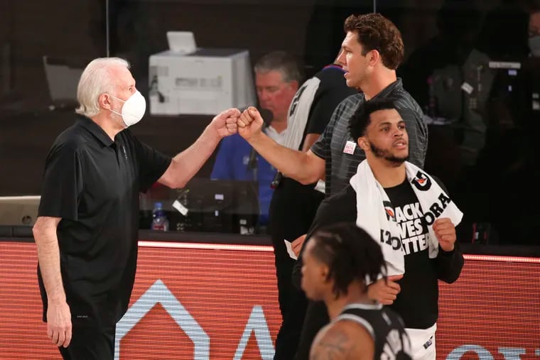 San Antonio Spurs head coach Gregg Popovich, left, and Sacramento Kings head coach Luke Walton greet each other after their game.
