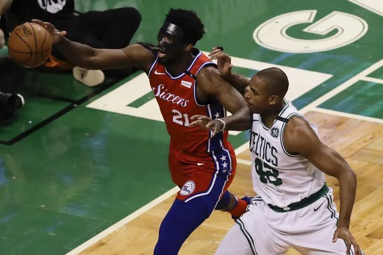 Sixers center Joel Embiid going after the basketball with Celtics forward Al Horford during the first quarter in Game 1.