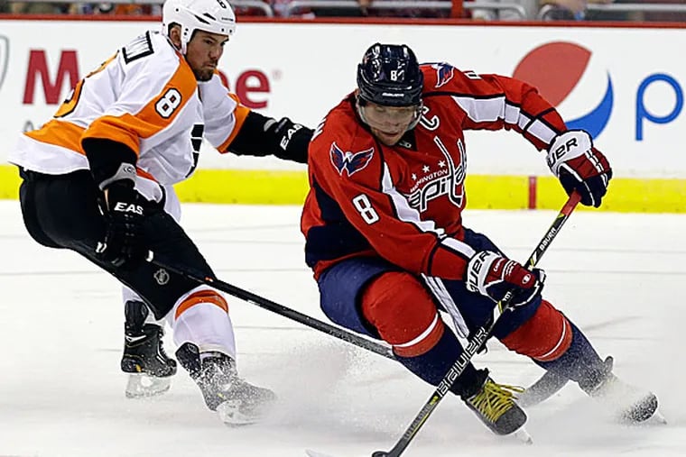 Capitals right wing Alex Ovechkin skates with the puck as he is defended by Flyers defenseman Nicklas Grossmann. (Alex Brandon/AP)