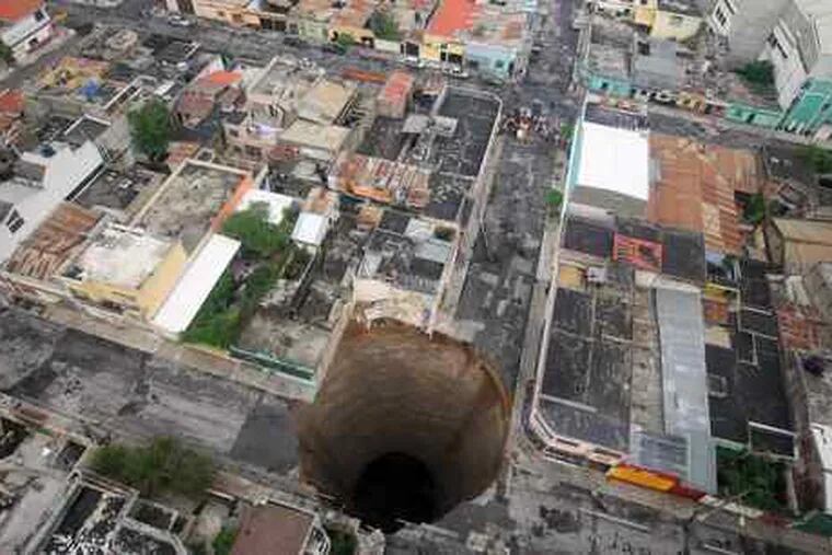 A huge sinkhole covers an intersection in Guatemala City. Authorities estimate the hole is 66 feet wide and nearly 100 feet deep.