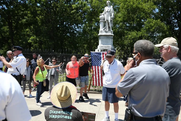 A group of pro-Columbus supporters (background) and anti-Columbus supporters (foreground) yell at each other in front of the Christopher Columbus statue in Marconi Plaza in Philadelphia in June 2020.