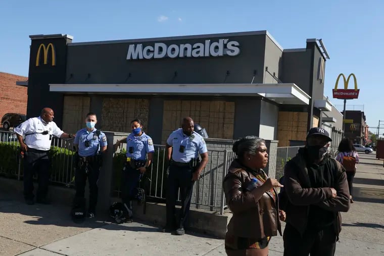 Philadelphia Police Department officers stand near a boarded up McDonalds in West Philadelphia before the verdict was announced in the trial of former Minneapolis police officer Derek Chauvin last month.